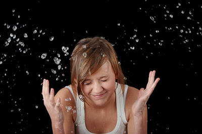 Teen girl washing her face with water